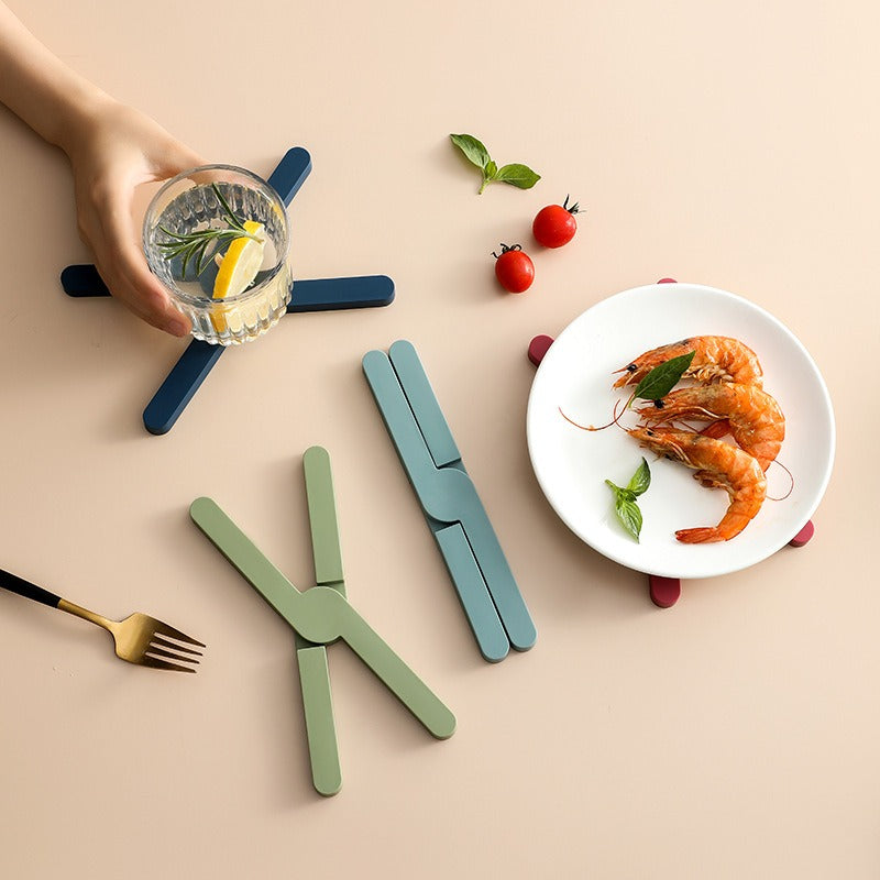 X-shaped heat-resistant silicone dining table mat with non-slip design. Protects surfaces from heat, spills, and scratches—stylish and practical for everyday use.