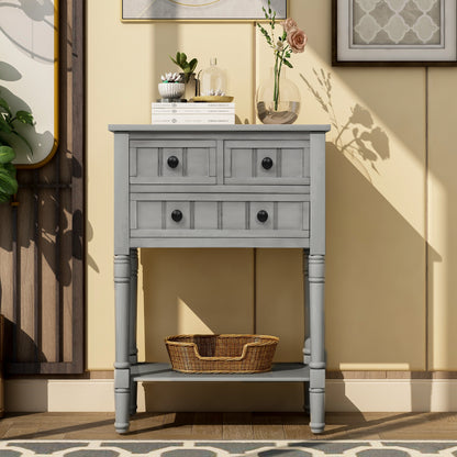 Slim grey-washed console desk with three drawers and bottom shelves. Space-saving sofa table perfect for living rooms, entryways, and hallways.